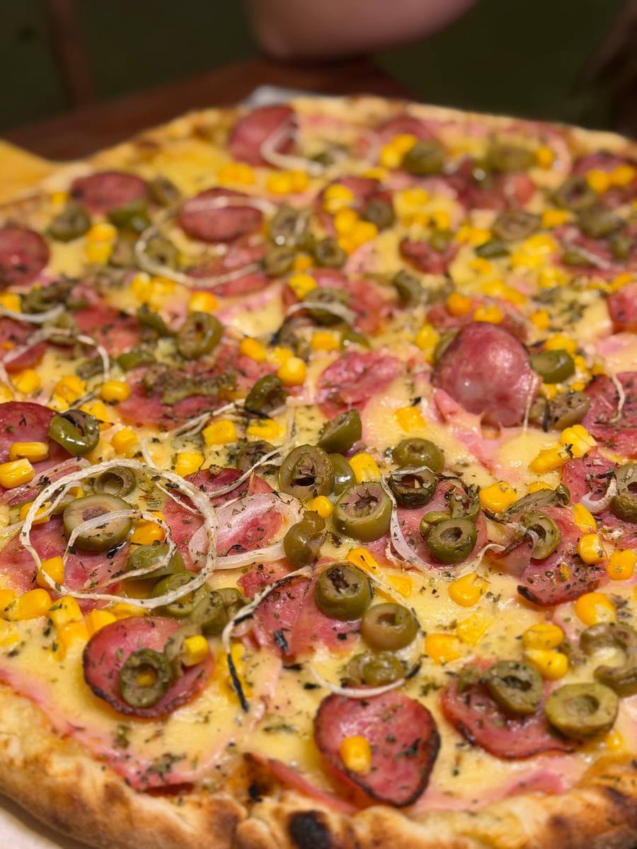 Detalhe da pizza de calabresa com azeitona e milho